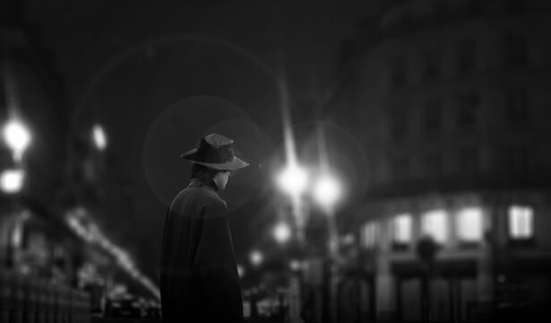 Fototapeta the dark silhouette of a male hat in a night street light.