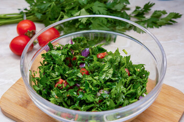 Close up on Tabbouleh salad made with parsley, cherry tomatoes, onion, lemon, olive oil and basil