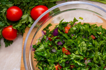 Close up on Tabbouleh salad made with parsley, cherry tomatoes, onion, lemon, olive oil and basil