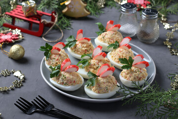 Stuffed eggs with crab sticks, a delicious festive snack. Closeup. Christmas composition. Horizontal format © Anzhela
