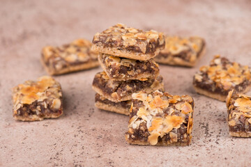 Confectioneries with nuts and chocolate, german christmas sweets, little cakes on a brown textured background, empty copy space for text