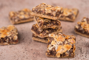 Confectioneries with nuts and chocolate, german christmas sweets, little cakes on a brown textured background, empty copy space for text