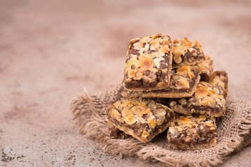 Confectioneries with nuts and chocolate, german christmas sweets, little cakes on a brown textured background, empty copy space for text