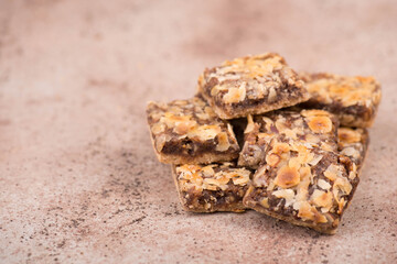 Confectioneries with nuts and chocolate, german christmas sweets, little cakes on a brown textured background, empty copy space for text