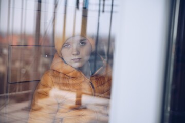 The boy by the window. A sad time. Coronavirus prevention.
