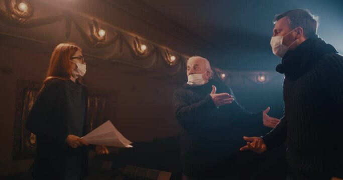 Actors in face masks acting out quarrel on stage