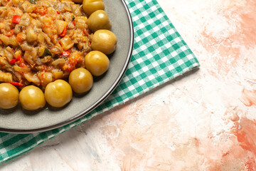 bottom half view roasted eggplant salad and pickled plums on plate on turquoise white checkered tablecloth on nude table