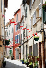 Ville d'Aubagne, vieille ruelle du centre historique, façades colorées et drapeaux, département des Bouches-du-Rhône, France
