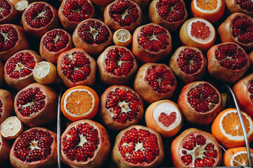 Sale of ripe juicy pomegranates, oranges in a street market. Open showcase of farmer's market
