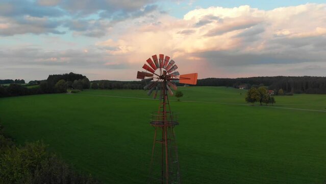 Drone shot rotating a old wind turbine at dusk