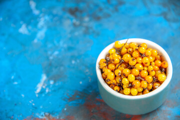 bottom view sea buckthorn on blue table copy space