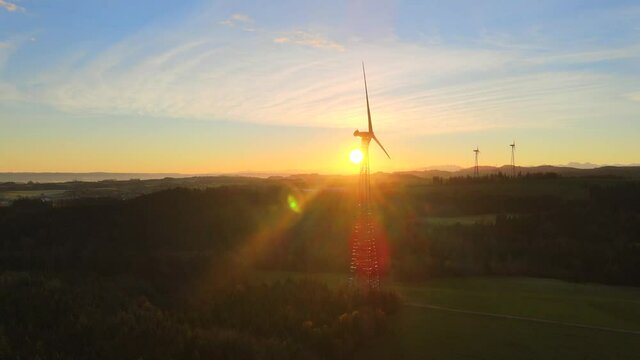 Drone shot panning in on wind turbine at sunrise