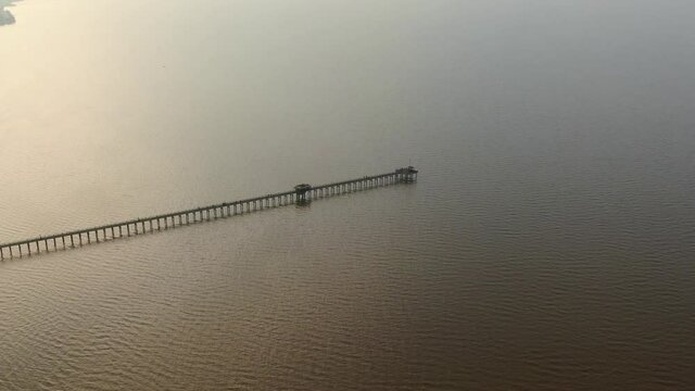 Vista a&eacute;rea durante el atardecer, de un muelle de pescadores en la costa, sobre un r&iacute;o muy ancho, el R&iacute;o de la Plata.
