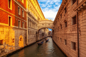 Fototapeta na wymiar Gondolas in the evening going under the Bridge of Sighs in Venice, Italy