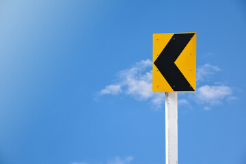 Yellow Chevron traffic sign. Reflective sign indicate the way to turn left on the curve ahead.