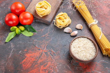 top view raw pasta with rice and tomatoes on a dark background pasta dough raw