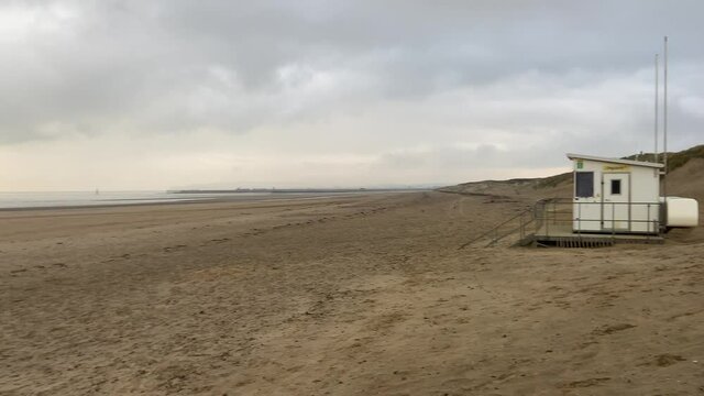 sunset beach storm beach camber sands in East Sussex, UK sand dunes pan to sunset low tide flat sandy beach 