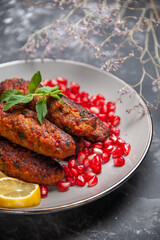 front view long meat cutlets with lemon and pomegranates on grey background meal roll dish