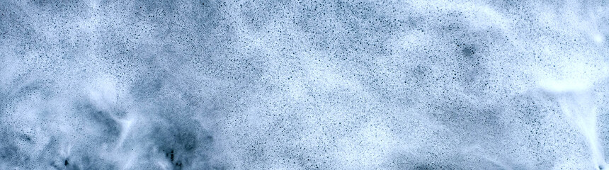 Froth and foam on dark turbulent water, very wide panoramic frame.