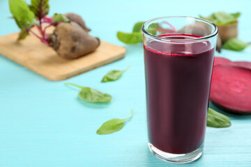 Fresh beet juice in glass on blue wooden table. Space for text