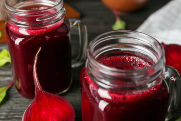 Fresh beet juice and raw vegetable on table, closeup