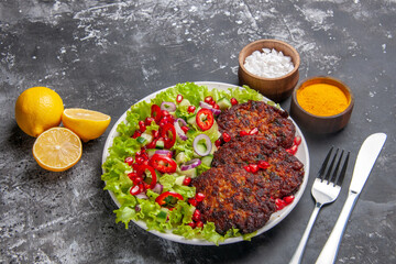 top view tasty meat cutlets with salad and seasonings on a grey background photo food dish