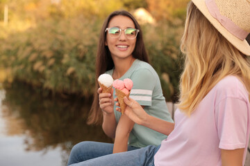 Young women with ice cream spending time together outdoors