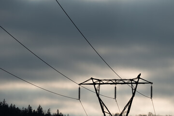 A wooden electric utility pole with electrical wires, transmission lines, conductors and...
