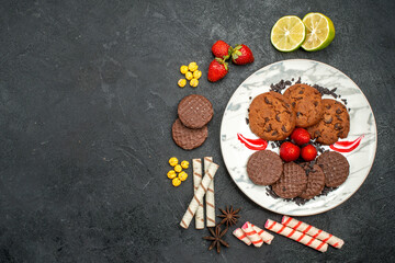 top view yummy choco biscuits with candies on dark background sweet cookies sugar tea