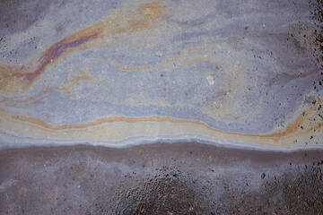 of the gasoline stain on the pavement road as a texture or background