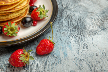 front view delicious pancakes with fruits and berries on a light background fruit cake sweet