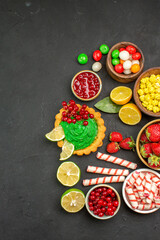 Fototapeta na wymiar top view yummy cake with fruits and candies on a dark background cookie biscuit sweet