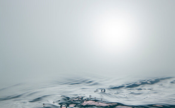 Blurred sea, there are small waves and bubbles on the water surface. The gloomy view of the sea when there is a storm.
