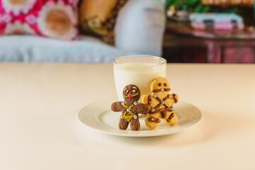 BDSM themed gingerbread cookies. fun looking cookies and a glass of milk. Sexy cookie with mouth ball and leather suit look designed in bsdm style.