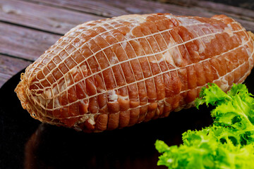 Boneless pork shoulder roast on wooden background.