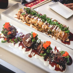 Delicious traditional japanese takoyaki and okonomiyaki omelette in a white plates