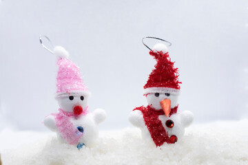 little snowmans standing in winter christmas landscape.