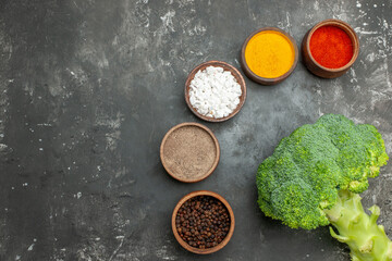 Fototapeta na wymiar Half shot of healthy meal with brocoli and carrots on a black plate and spices stock image