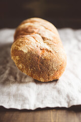 Freshly baked bread on the old wooden table. Selective focus. Shallow depth of field. 
