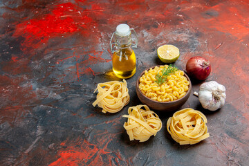 Uncooked three spaggeties and butterfly pastas in a brown bowl and green onion lemon garlic oil...
