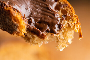 Fototapeta premium Eating slice of homemade bread with chocolate cream for breakfast. Selective focus. Shallow depth of field. 