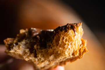 Eating slice of homemade bread with chocolate cream for breakfast. Selective focus. Shallow depth of field. 