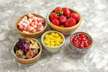 front view fresh red strawberries with candies on white background fruit sweet candy color