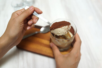 Young woman eating traditional dessert tiramisu. Soft focus image.