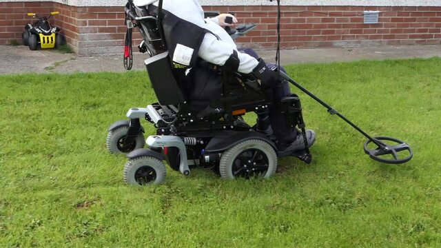 Disabled Wheelchair user metal detecting in a field