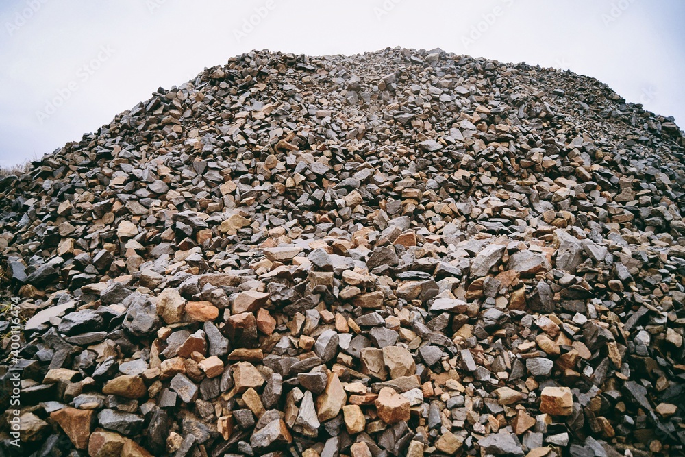 Wall mural pile of wet gravel or stone in construction site on sky background.