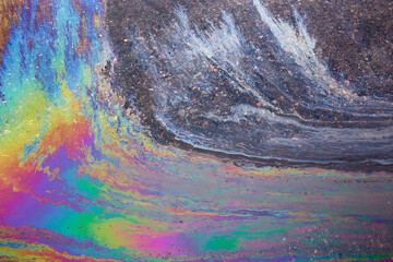 Colored oil stains close up, the color of the gasoline stain on the pavement road as a texture or background.