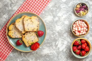 top view cake slices with fresh strawberries and candies on light background pie fruits