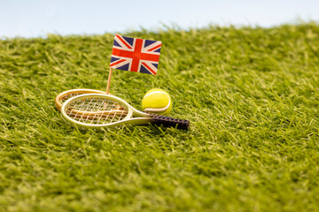 Tennis England with racket and ball with Union Jack flag on green grass