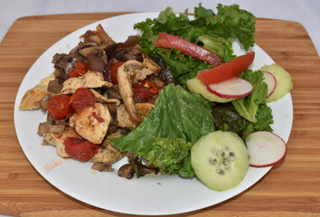 Plate of some chicken fajitas and salad on a wooden table
